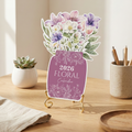 Floral-themed 2026 calendar on a stand with decorative elements on a wooden surface.